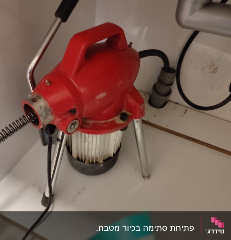 מכונת ניקוי צינורות אדומה עם ידית שחורה